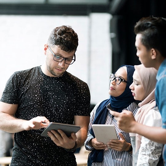 people discussing with tablets