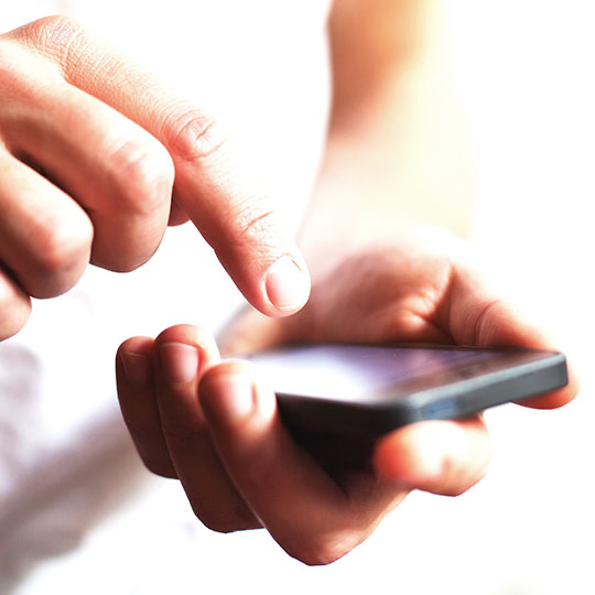 Close up of hands typing on a smartphone