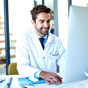 male doctor working on a desktop computer