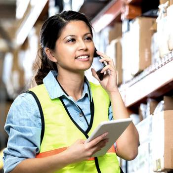 Hankintatoimi warehouse worker on the phone holding a tablet